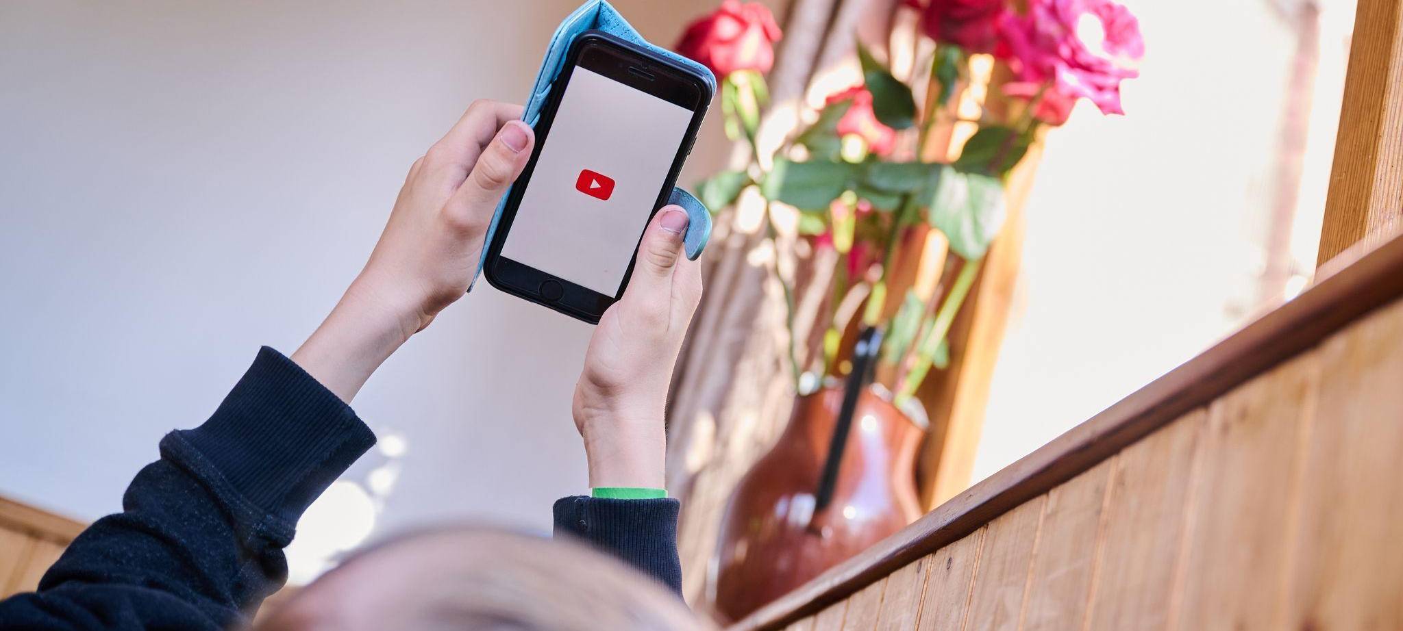 Junge öffnet auf seinem Smartphone die App von YouTube