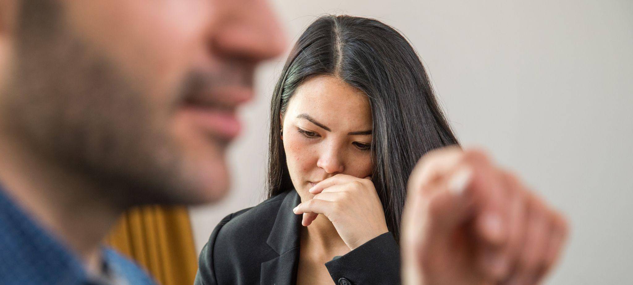Frau schaut niedergeschlagen während eines Gesprächs