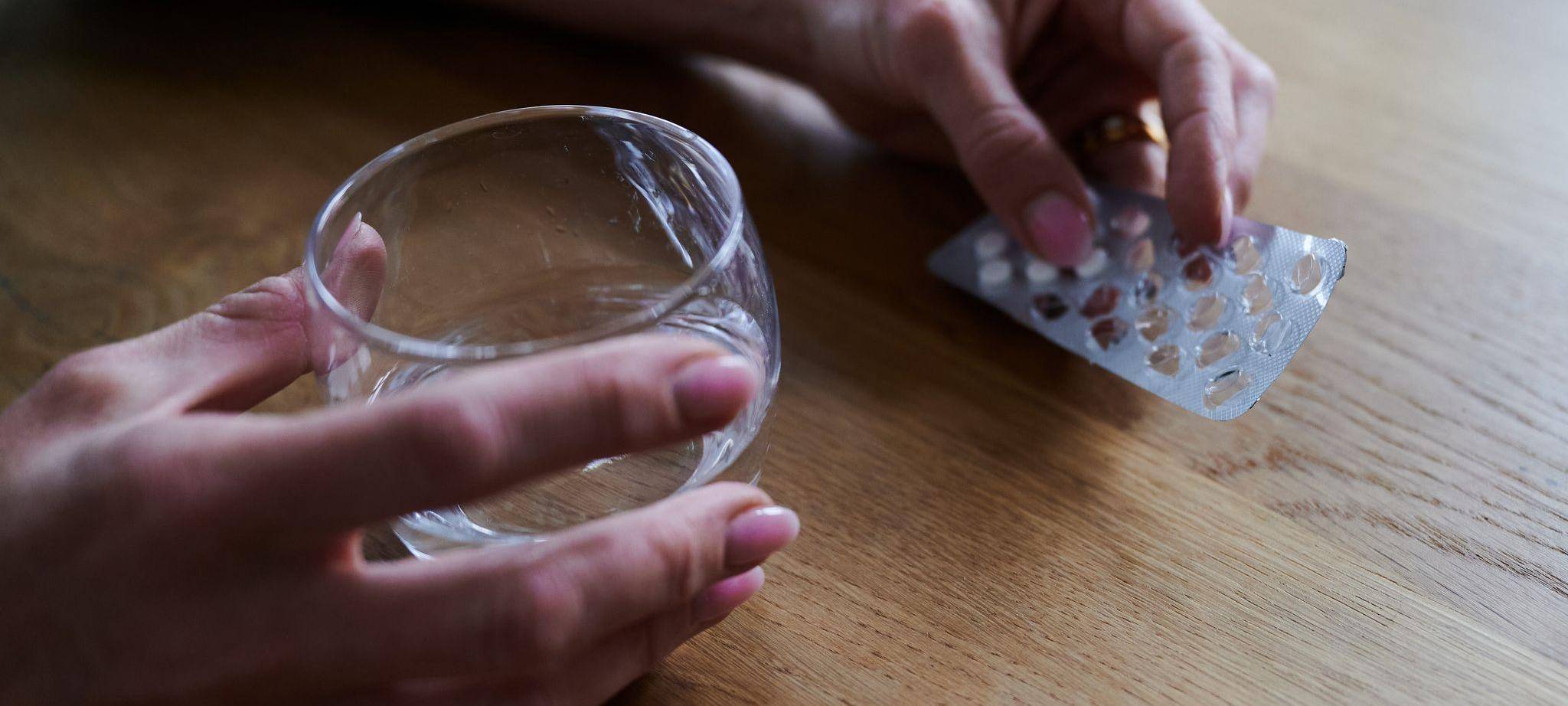 Frau hält Tabletten in der Hand