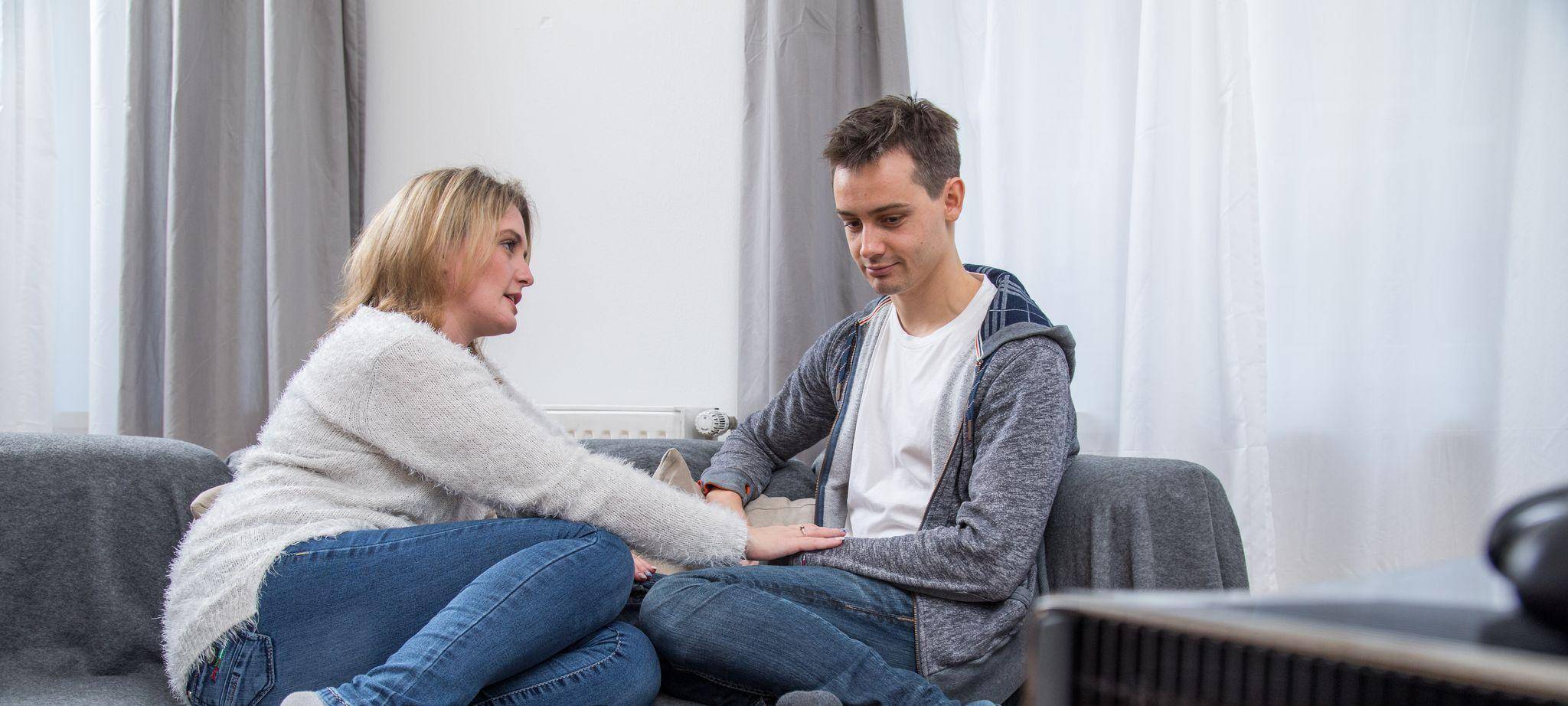 Eine Frau und ein Mann unterhalten sich auf dem Sofa
